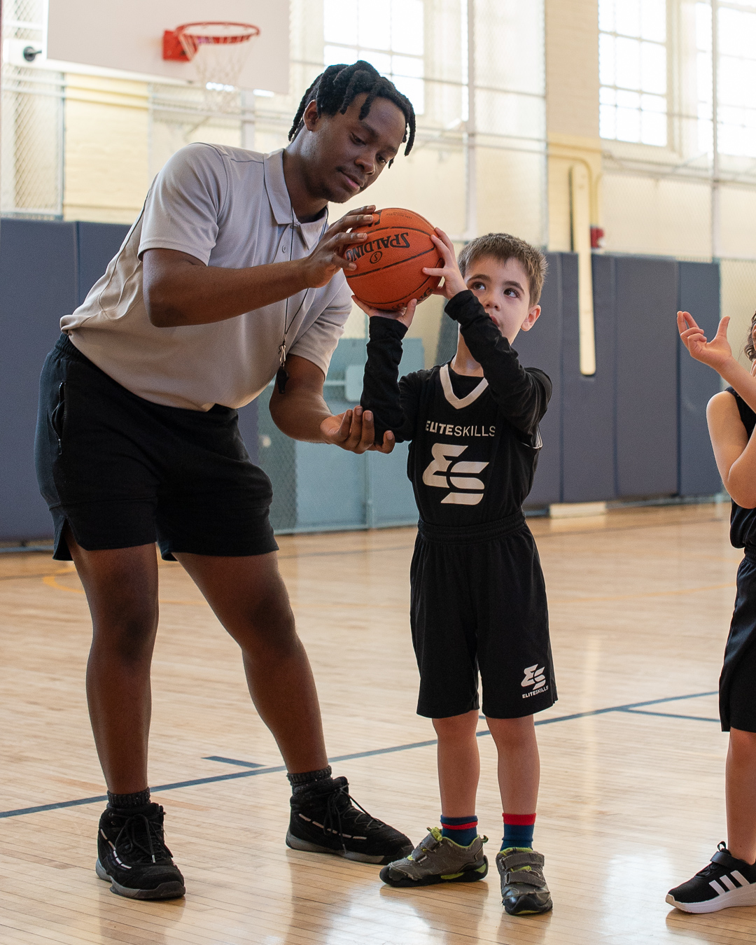 Coach guiding a young player's shooting form